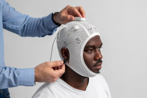 Person wearing BrainBit Flex mesh cap for remote neurofeedback training at home